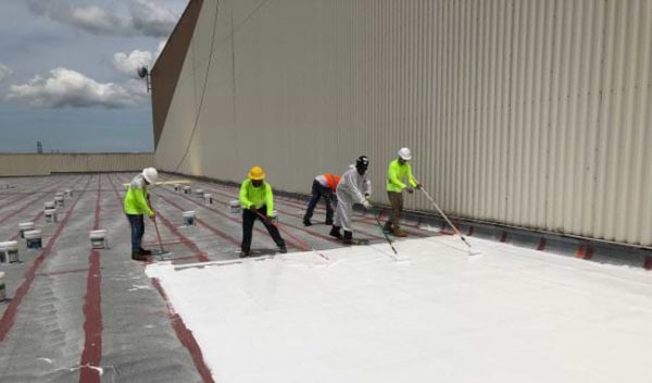 Our crew applying a silicon roof coating on this commercial building in Pasco County.